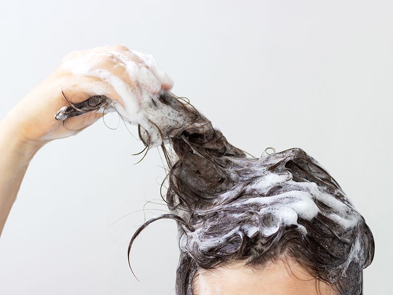 Cabeza con el pelo mojado y la espuma del champú.